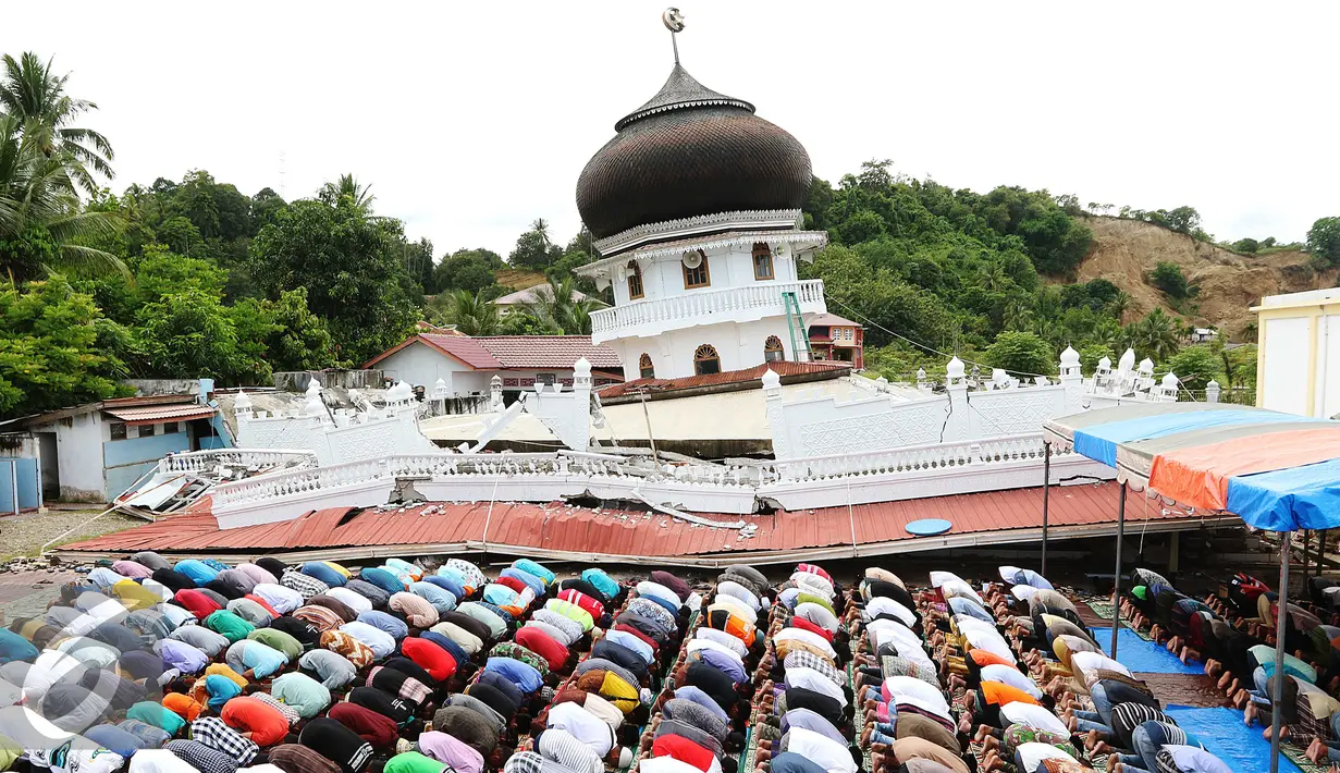 Suasana Salat Jumat warga Pidie di halaman Masjid Jami Quba, Aceh, Jumat (9/12). Gempa berkekuatan 6,5 SR telah merobohkan ratusan bangunan termasuk Masjid Jami Quba. (Liputan6.com/Angga Yuniar)