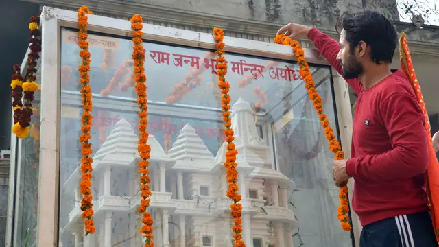 Seorang anggota umat Hindu Bajrang Dal memasang karangan bunga model kuil Ram saat prosesi memperingati 24 tahun pembongkaran Masjid Babri di Ayodhya, di Amritsar pada 6 Desember 2016.
