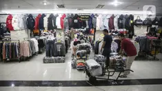 Dua orang pria menata pakaian impor bekas di Metro Atom Pasar Baru, Jakarta, Selasa (19/7/2022). Wakil Ketua DPR RI Bidang Korinbang Rachmat Gobel menyayangkan Indonesia masih melakukan impor pakaian bekas. (Liputan6.com/Faizal Fanani)
