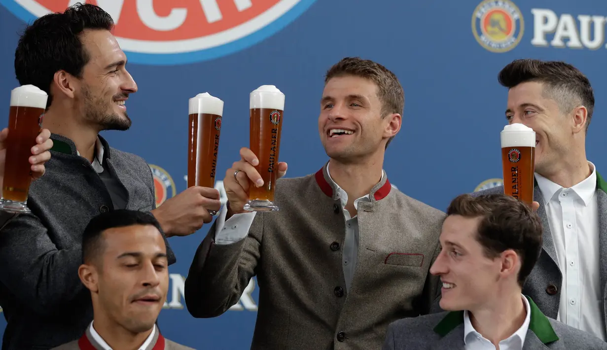 Pemain Bayern Mats Hummels, Robert Lewandowski dan Thomas Mueller bersulang saat melakukan pemotretan perusahaan bir di Munich, Jerman, (13/9). Sebelumnya Bayern menorehkan kemenangan atas Anderlecht 3-0 di Liga Champions. (AP Photo/Matthias Schrader)