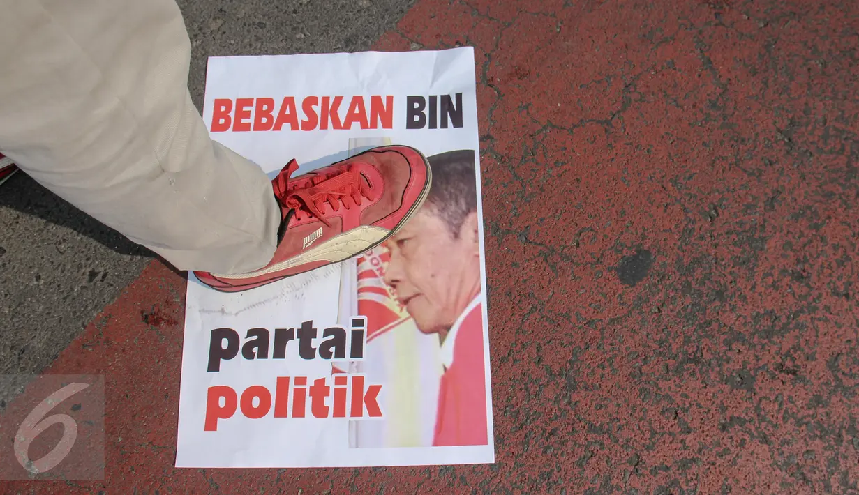 Salah satu aktivis Pemuda Untuk Keadilan dan Persatuan Indonesia (PKPI) menginjak poster yang berisikan penolakan pencalonan Sutiyoso jadi kepala BIN saat aksi damai di Bundaran HI, Jakarta, Minggu (28/6/2015). (Liputan6.com/Faizal Fanani)