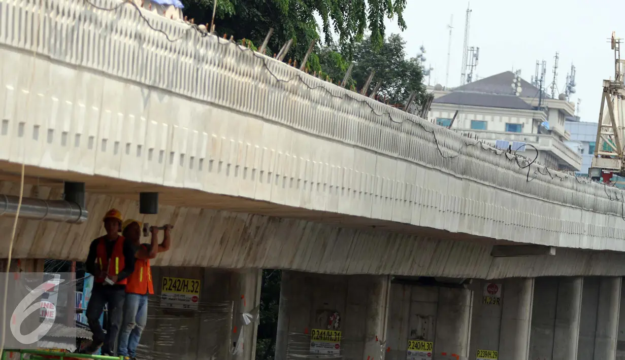 Pekerja menyelesaikan pemasangan pipa pembuangan air pada proyek jalan layang transjakarta Tandean-Ciledug, Jakarta, Selasa (13/9). Jalan layang non tol dengan panjang 9,3 kilometer itu akan selesai akhir 2016 mendatang. (Liputan6.com/Helmi Afandi)