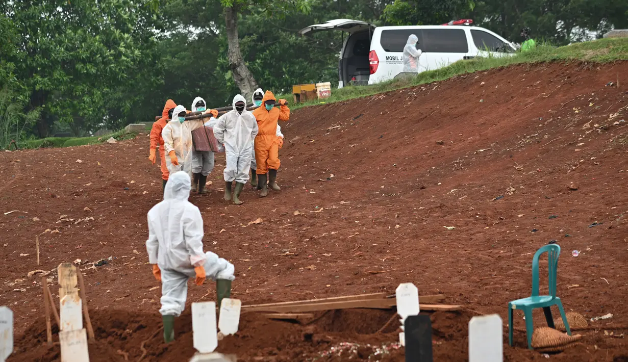 Petugas membawa peti jenazah berisi korban virus corona COVID-19 ke sebuah pemakaman di Jakarta, Rabu (15/4/2020). Hingga sore ini, jumlah kasus COVID-19 di Indonesia sebanyak 5.136 positif, 446 sembuh, dan 469 meninggal dunia. (Bay ISMOYO/AFP)