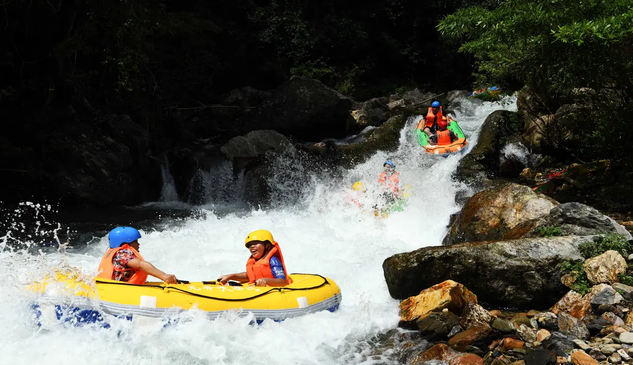 Sejumlah wisatawan bermain arung jeram di Wilayah Longsheng, Daerah Otonom Etnis Zhuang Guangxi, China selatan (3/8/2020). Warga China menghabiskan waktu senggang dengan beraktivitas bermain air saat musim panas. (Xinhua/Wu Shengbin)