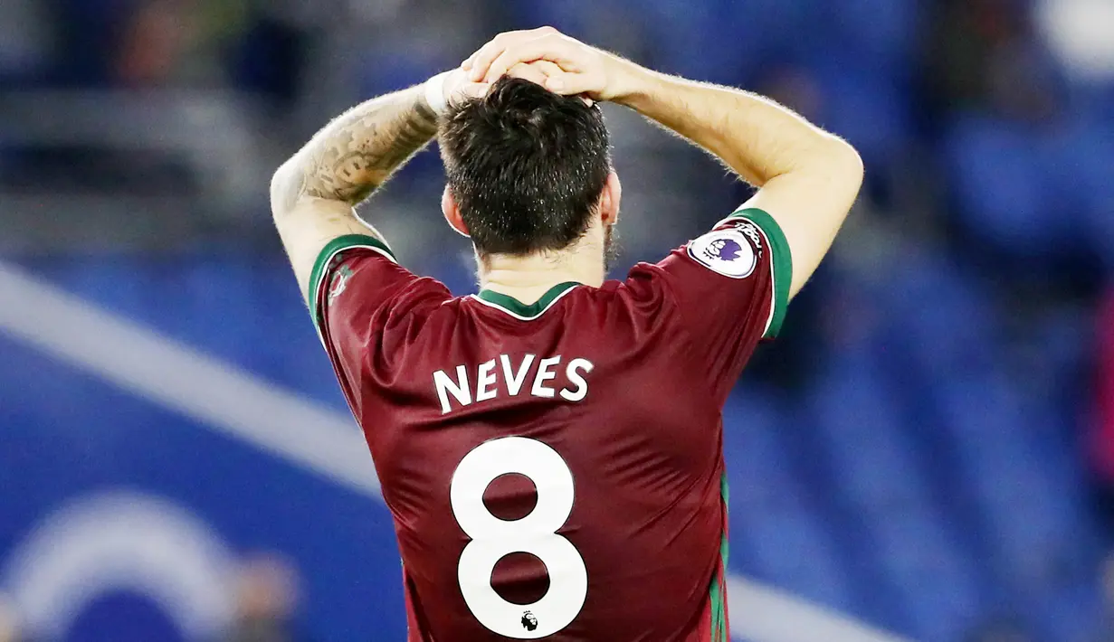 Pemain Wolverhampton Wanderers, Ruben Neves, memegang kepalanya saat melawan Brighton and Hove Albion pada laga Liga Inggris di Stadion Amex, Sabtu (2/1/2021). Kedua tim bermain imbang 3-3. (Gareth Fuller/POOL/AFP)