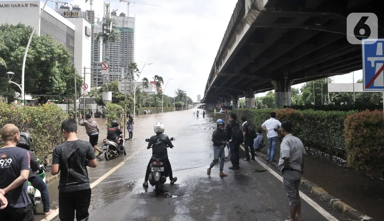 Pengendara terjebak banjir saat keluar dari Gerbang Tol Cempaka Putih, Jakarta, Minggu (23/2/2020).  Banjir yang melanda kawasan Cempaka Putih dan sekitarnya melumpuhkan akses di Jalan Ahmad Yani sehingga Gerbang Tol Pulomas dibuka untuk pengendara sepeda motor. (merdeka.com/Iqbal S. Nugroho)
