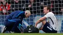 Penyerang Tottenham Hotspur, Harry Kane (kanan) mendapat perawatan tim medis setelah mengalami cedera saat melawan Bournemouth di Liga Inggris di Stadion Vitalitas di Bournemouth (11/3). Kane mengalami cedera pergelangan kaki. (AFP Photo/Adrian Dennis)