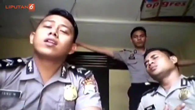 Polisi yang berdiri di belakang memainkan suling buatan sambil berjoget dengan lemah gemulai.