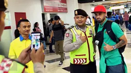 Polisi berfoto dengan pemain Timnas Indonesia, Stefano Lilipaly di Bandara Soekarno Hatta, Tangerang, Minggu (18/12). Sebelumnya, Indonesia melakoni laga final kedua Piala AFF 2016 kontra Thailand. (Liputan6.com/Helmi Fithriansyah)