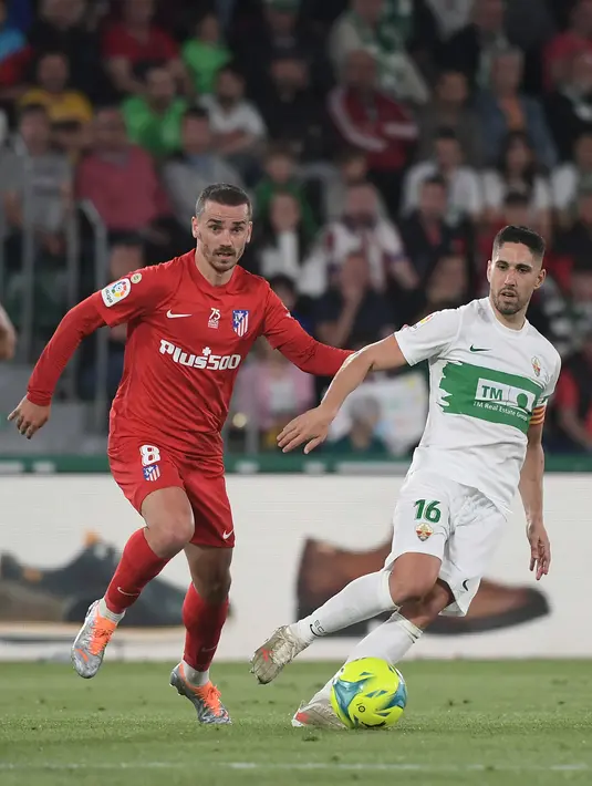 <p>Penyerang Atletico Madrid Antoine Griezmann (kiri) berebut bola dengan gelandang Elche CF Fidel Chaves pada jordana ke-36 La Liga Spanyol 2021/2022 di Estadio Martinez Valero, Kamis (12/5/2022) dini hari WIB. Atletico Madrid sukses menaklukkan tuan rumah Elche dengan skor meyakinkan 2-0. (JOSE JORDAN / AFP)</p>