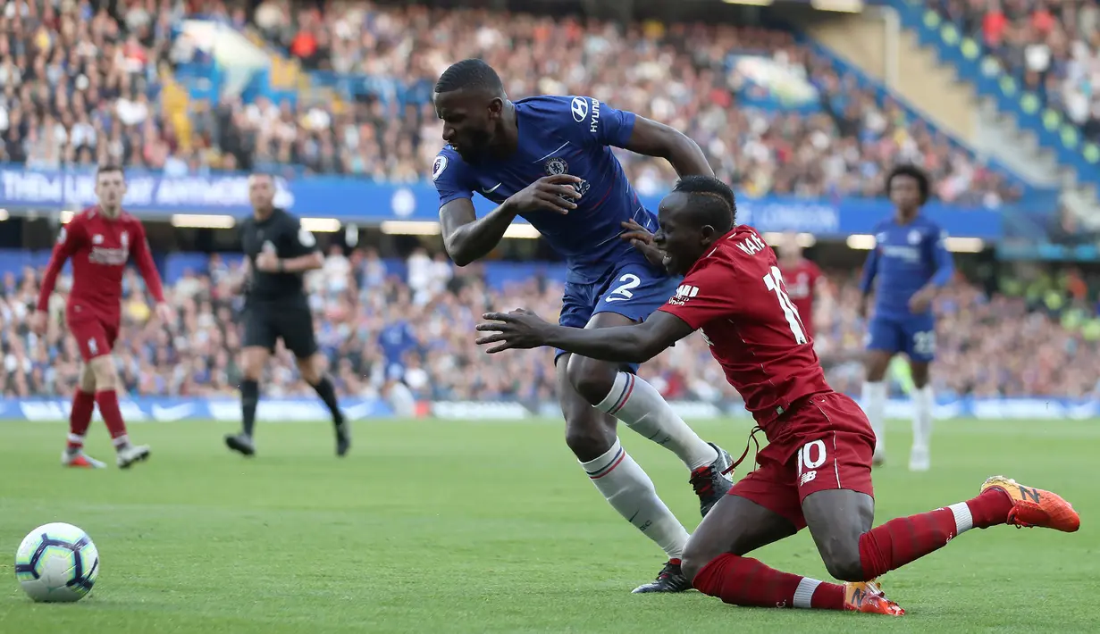 Bek Chelsea, Antonio Rudiger, menjatuhkan striker Liverpool, Sadio Mane, pada laga Premier League di Stadion Stamford Bridge, London, Sabtu (29/9/2018). Kedua klub bermain imbang 1-1. (AFP/Daniel Leal-Olivas)