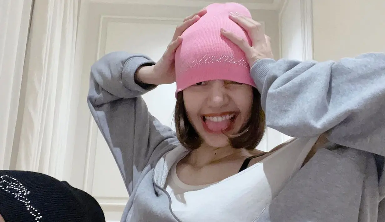 Berpose dengan gaya nyentrik dengan temannya, Lisa terlihat mengenakan tank top putih yang ditumpuknya dengan jaket hoodie abu-abu dan beanie hat berwarna pink. Foto: Instagram.