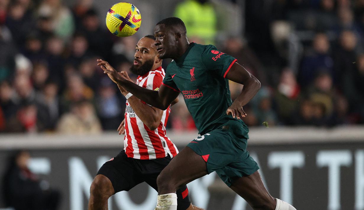 Bek Liverpool, Ibrahima Konate (kanan) berebut bola dengan striker Brentford, Bryan Mbeumo pada laga Liga Inggris 2022/2023 di Gtech Community Stadium, London (2/1/2023). Ibrahima Konate didatangkan Liverpool dari RB Leipzig pada awal musim 2021/2022. Ia tampil lumayan di posisi bek tengan The Reds hingga kini meski baru bermain dalam 8 laga di Liga Inggris musim. Nyatanya ia hanya digaji 71 ribu pound sterling atau setara Rp1,3 miliar per pekan, masih lebih kecil dari pemain yang sama sekali belum melakukan debut bareng The Reds, yaitu Arthur Melo. (AFP/Adrian Dennis)