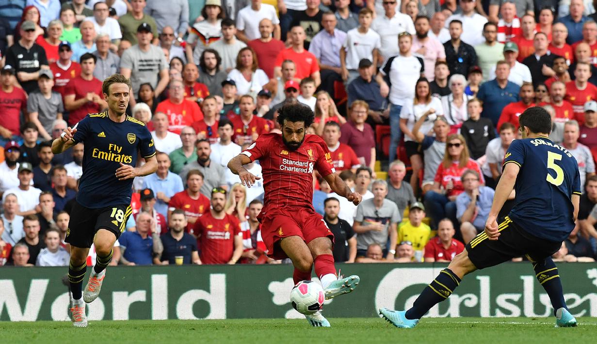 Gelandang Liverpool Mohamed Salah (tengah) menendang bola ke gawang Arsenal saat bertanding dalam Liga Inggris di Stadion Anfield, Liverpool, Inggris, Sabtu (24/8/2019). Liverpool menang 3-1 dan kukuh di puncak klasemen sementara. (BEN STANSALL/AFP)