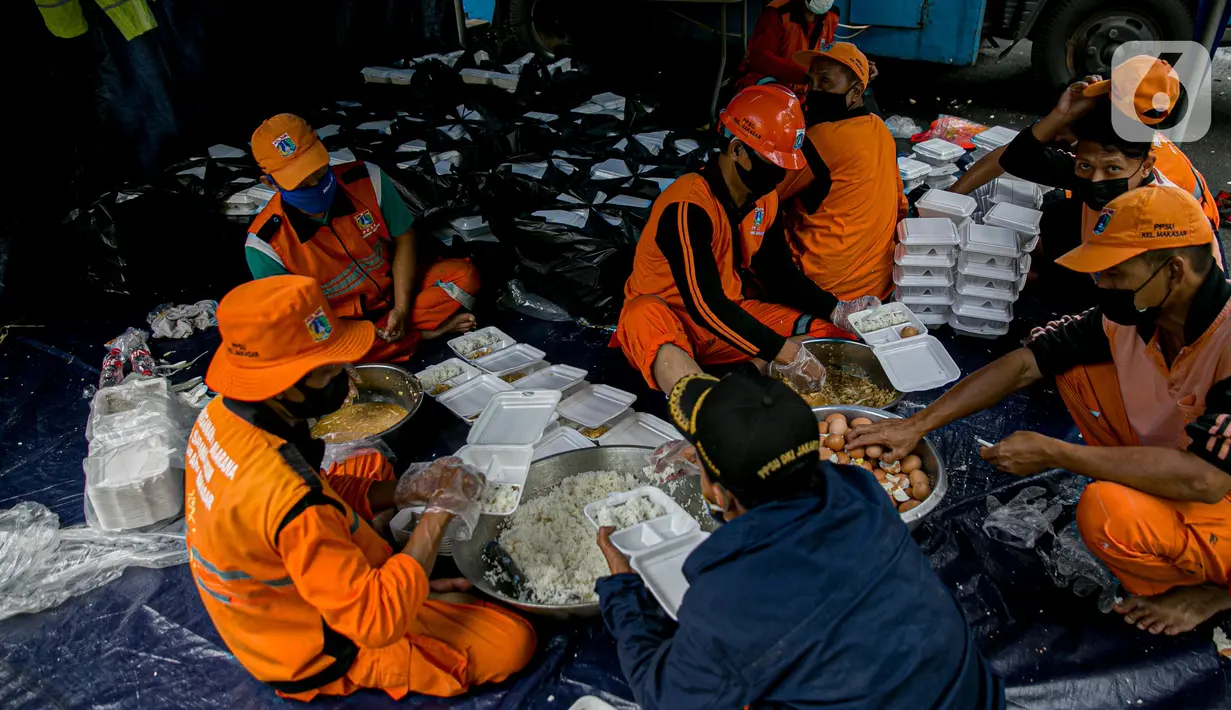 Petugas PPSU mengemas makanan di Dapur Umum Kementerian Sosial di GOR Otista, Jakarta, Minggu (21/2/2021). Dalam sehari, petugas menyiapkan hingga 6.000 paket nasi kotak yang didistribusikan ke 11 kelurahan terdampak banjir. (Liputan6.com/Faizal Fanani)