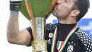 Kiper Juventus, Gianluigi Buffon mencium trofi Liga Italia di Juventus Stadium, Turin, (21/5). Juventus menjadi tim pertama dalam sejarah yang bisa meraih enam scudetto secara beruntun. (Alessandro Di Marco/ANSA via AP)