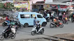 Sejumlah kendaraan melintasi perlintasan kereta api Nomor 52 di Pisangan Lama, Jakarta, Kamis (11/4). Pintu perlintasan ini dan JPL 66 di Jalan Stasiun Cakung akan ditutup permanen saat diberlakukannya Double Double Track (DDT) lintas Manggarai-Cikarang. (merdeka.com/Iqbal S. Nugroho)