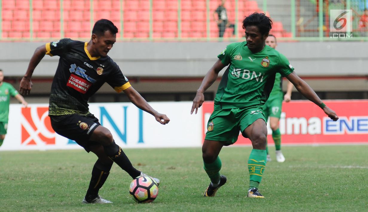 Penyerang Bhayangkara FC, Ilham Udin Armaiyn (kanan) mencoba merebut bola dari pemain Sriwijaya FC, Achmad Faris A pada lanjutan Liga 1 Indonesia di Stadion Patriot Candrabhaga, Bekasi,, Minggu (20/8). (Liputan6.com/Helmi Fithriansyah)
