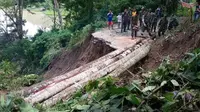 Jembatan darurat yang terbuat dari beberapa batang pohon ini dibuat agar masyarakat dapat menjalankan aktifitas keseharian.
