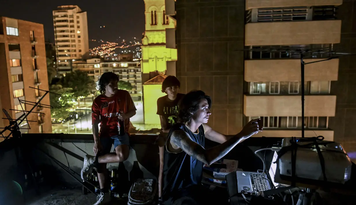 Aktivis @lanuevabandadelaterraza memproyeksikan gambar di dinding gedung di Medellin, Kolombia, 9 Agustus 2020. Karena protes dibungkam akibat lockdown COVID-19, tuntutan sosial dan politik diproyeksikan ke gedung-gedung di Amerika Latin yang dibagikan melalui jejaring sosial (JOAQUIN SARMIENTO/AFP)