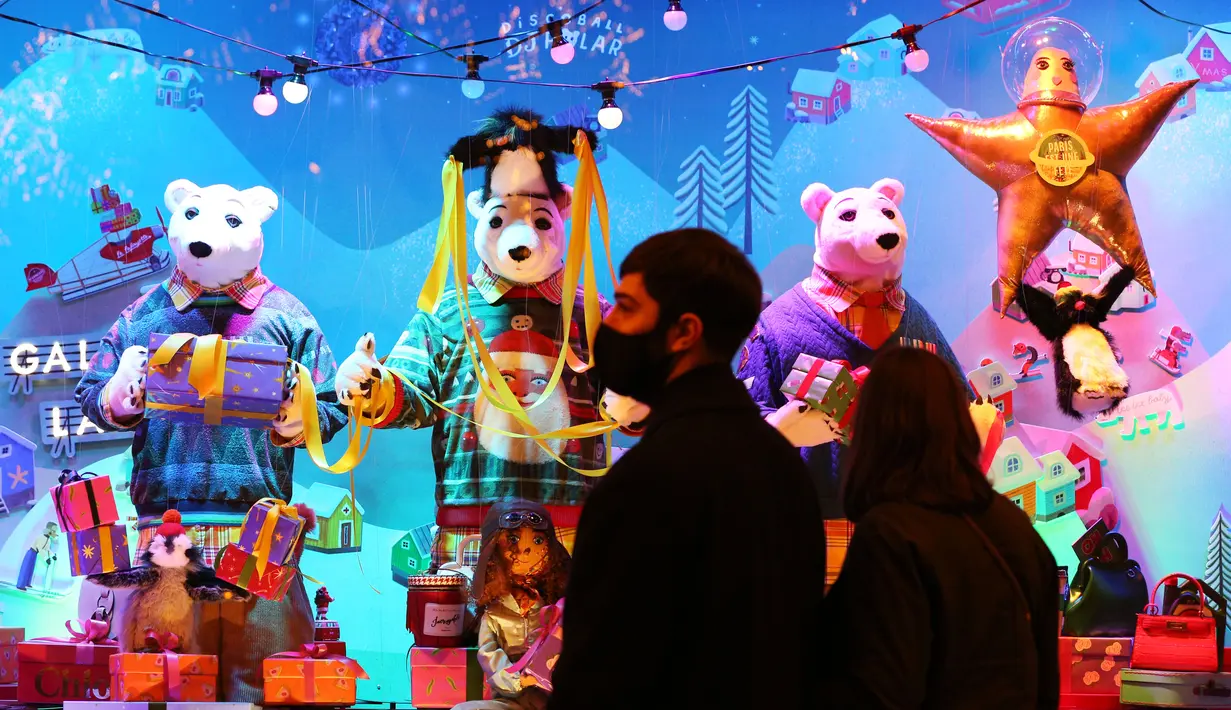 Para pejalan kaki berhenti untuk melihat etalase Natal di pusat perbelanjaan Galeries Lafayette di Paris, Prancis, pada 22 November 2020. Deretan pusat perbelanjaan telah meluncurkan etalase Natal mereka meskipun masih tutup selama karantina wilayah kedua di seluruh Prancis. (Xinhua/Gao Jing)