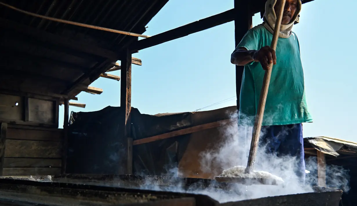 Seorang petani mengolah garam dengan cara tradisional di sebuah tambak di Lamnga, pinggiran Banda Aceh, Aceh, Selasa (7/3/2023). Petani Aceh memilih menggunakan teknologi sederhana dalam memproduksi garam dengan sistem rebus. (CHAIDEER MAHYUDDIN/AFP)