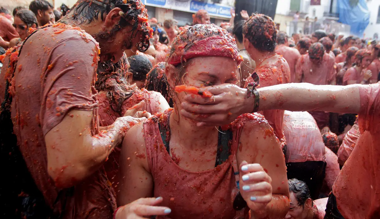 Puluhan ribu orang saling melempari tomat dengan penuh keriaan di Bunol saat Festival Tomatina, Valencia, Spanyol, Rabu (31/8). Akibatnya, jalanan pun menjadi merah dan basah oleh tomat. (REUTERS / Heino Kalis)