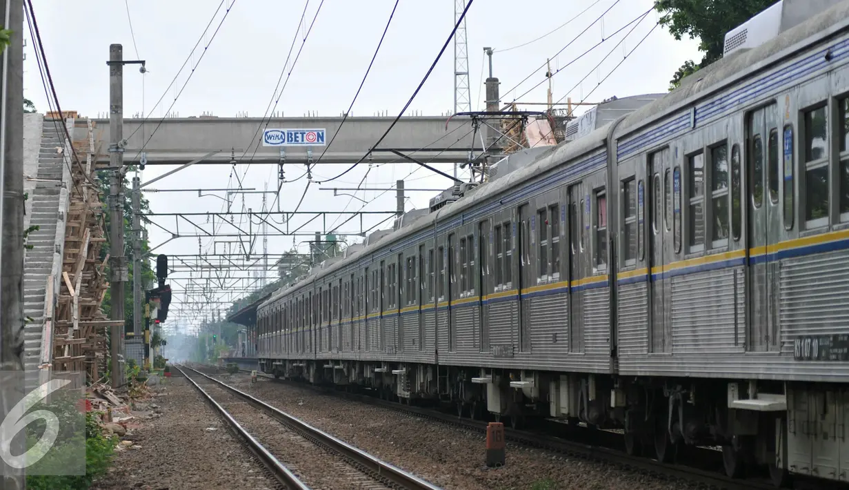 Kereta melintas di samping proyek pembangunan JPO di Stasiun Pasar Minggu Baru, Jakarta (30/11). Proyek yang menghabiskan dana APBD sekitar Rp 800 juta merupakan upaya untuk mengurangi angka kecelakaan di lintasan kereta api. (Liputan6.com/Yoppy Renato)