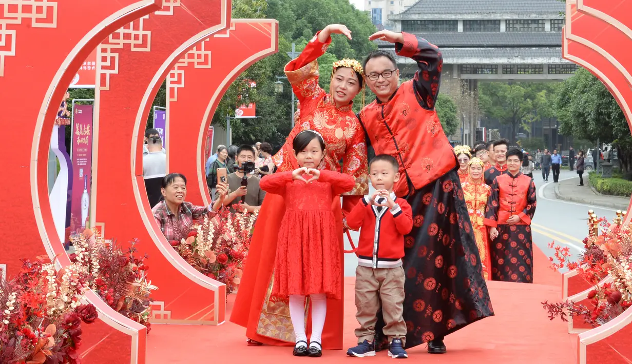 Sepasang mempelai berpose dengan para pengiring pengantin dalam pernikahan massal bergaya China di Changsha, Provinsi Hunan, China, 25 September 2020. Sebanyak 71 pasangan resmi menjadi suami-istri usai mengikuti upacara pernikahan tradisional dalam acara nikah massal. (Xinhua/Chen Zhenhai)