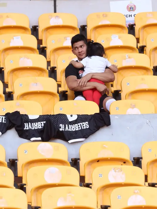 Istri pemain film 'The Raid 2: Berandal' itu juga membantu membawa tas besar perlengakapan suaminya main bola. (Andy Masela/Bintang.com)