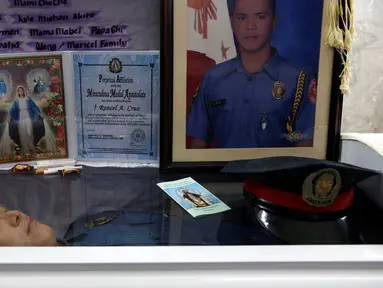  Jasad petugas kepolisian Filipina, Rancel Cruz terbaring di atas peti mati usai ditembak pecandu narkoba di Manila, Filipina, (19/10). Langkah tegas pemerintah Filipina membuat para pengguna narkoba membalas menembak petugas. (REUTERS/Erik De Castro)