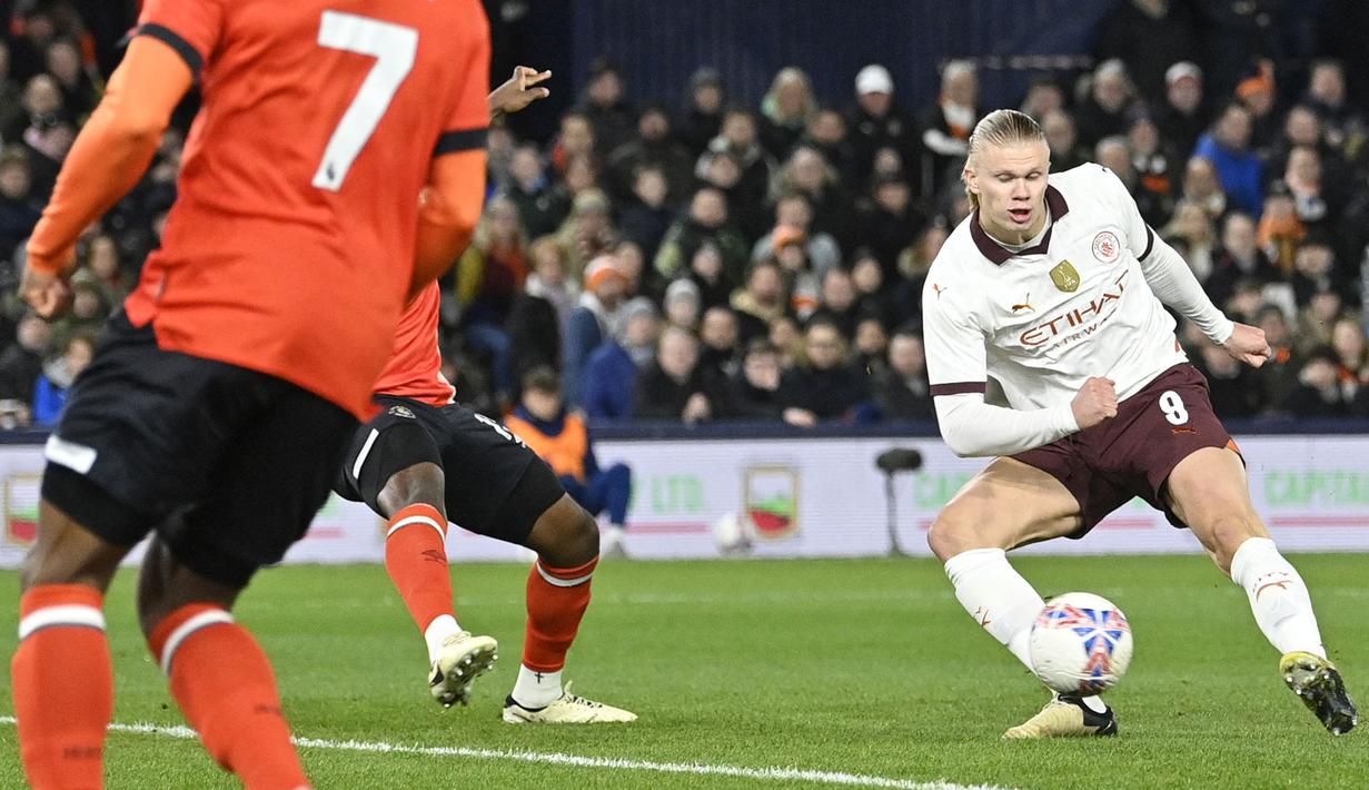 Pemain Manchester City, Erling Haaland (kanan) berusaha mencetak gol ke gawang Luton Town pada laga putaran kelima Piala FA 2023/2024 yang berlangsung di Kenilworth Road Stadium, Luton, Inggris, Rabu (28/02/2024) dini hari WIB. (AFP/Justin Tallis)