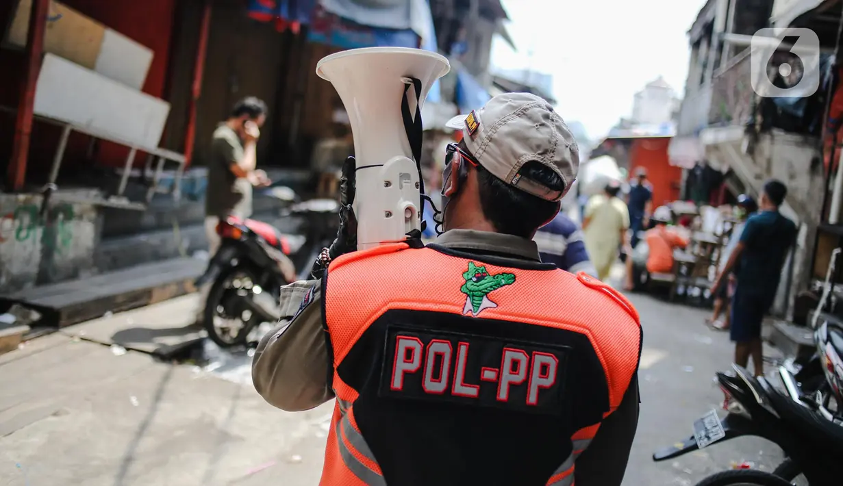 Petugas Satpol PP melakukan sosialisasi saat menertibkan pedagang yang nekat berjualan selama masa pandemi COVID-19 di kawasan Pasar Tanah Abang, Jakarta, Jumat (22/5/2020). Gubernur DKI Jakarta Anies Baswedan menambah PSBB selama 14 hari mulai tanggal 22 Mei 2020. (Liputan6.com/Faizal Fanani)