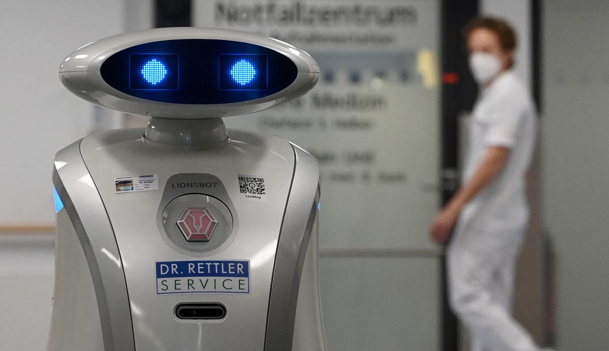 Robot pembersih 'Franzi' membersihkan area pintu masuk rumah sakit di Munich Neuperlach, Jerman selatan pada 12 Februari 2021. Di masa pandemi COVID-19, robot pembersih Franzi telah mempunyai peran baru, yaitu menghibur staf dan pasien di rumah sakit Munich. (Photo by Christof STACHE / AFP)