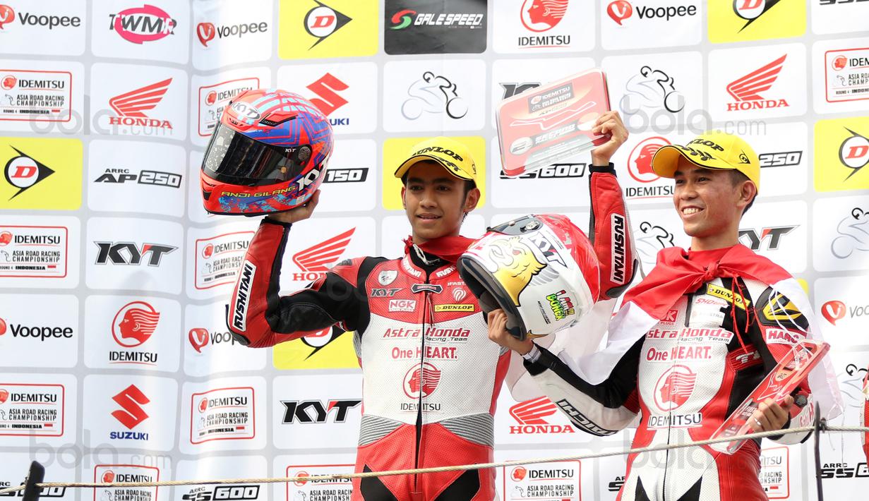 Pebalap Indonesia, Gerry Salim (kanan) dan Andi Gilang saat naik podium pada kelas Asia Production 250cc Asia Road Racing Championship di Sentul International Circuit, Bogor (13/8/2017). Gerry berhasil menjuarai nomor 250cc. (Bola.com/Nicklas Hanoatubun)