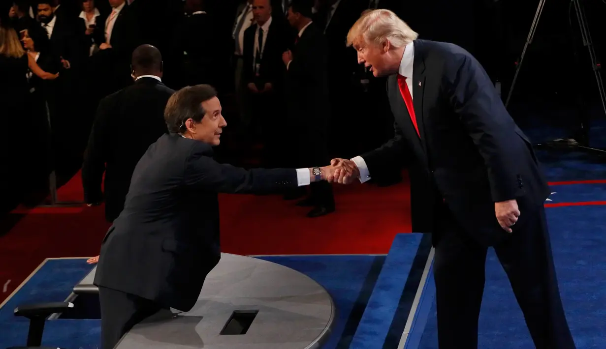 Capres AS dari Partai Republik, Donald Trump berjabat tangan dengan presenter Fox News Chris Wallace yang menjadi moderator seusai perhelatan debat ketiga dan terakhir capres AS di University of Nevada, Las Vegas, Rabu (19/10). (REUTERS/Mark Ralston/Pool)
