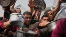 Badan PBB untuk Pengungsi Palestina (UNRWA) mengatakan, upaya mereka untuk menyalurkan bantuan kemanusiaan ke Jalur Gaza masih terhambat akibat blokade Israel yang dilakukan sejak Maret 2025 lalu. Tampak dalam foto, warga Palestina berebut menerima makanan sumbangan di dapur umum, Khan Younis, Jalur Gaza selatan, Jumat 6 Februari 2026. (AP Photo/Abdel Kareem Hana)