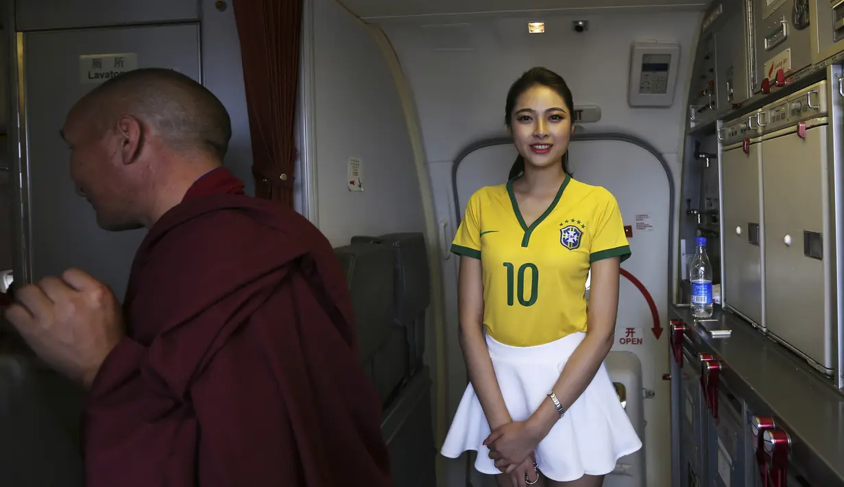 Pramugari salah satu maskapai penerbangan lokal di China mengenakan kaos bola saat bertugas, Senin (23/6/14). (REUTERS/Wong Campion)