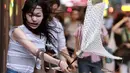 Seorang wanita memegang payung yang rusak akibat tiupan angin Topan Soudelor mendekati wilayah Taipei, Taiwan, (7/8/2015). Kuatnya angin yang disebabkan oleh efek Topan Soudelor membuat payung yang digunakan para pejalan kaki rusak. (REUTERS/Pichi Chuang)