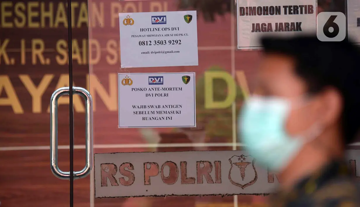 Sejumlah informasi terpasang pada pintu kaca di Posko Ante Mortem-DVI RS Polri Jakarta, Selasa (12/1/2021). Hingga saat ini, tim DVI masi mengumpulkan sampel DNA penumpang pesawat Sriwijaya Air SJ 182 yang jatuh di perairan Kepualauan Seribu. (merdeka.com/Imam Buhori)