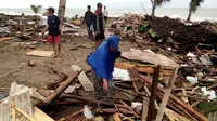 Warga memeriksa kerusakan rumah mereka setelah tsunami menerjang Pantai Carita, di perairan Banten, Minggu (23/12). Data sementara jumlah korban dari bencana tsunami di Selat Sunda tercatat 584 orang luka-luka dan 2 orang dinyatakan hilang. (SEMI / AFP)