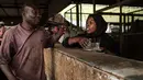 Seorang wanita berbicang dengan pegadang ikan setelah menjual teh di sebuah pasar ikan di dekat Sungai Nil, di kota kembar Khartoum, Omdurman (24/6/2019). Kota Omdurman didirikan pada tahun 1884. (AFP Photo/Yasuyoshi Chiba)