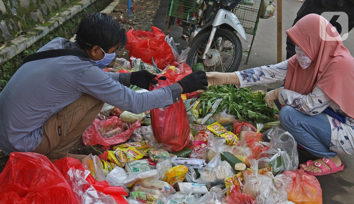 Pedagang sayur keliling melayani pembeli di Taman Anyelir 3, Depok, Selasa (28/4/2020). Warga di wilayah Taman Anyelir 3 menerapkan pembatasan jarak fisik agar tidak terjadi penumpukan pelanggan saat berbelanja sebagai upaya pencegahan penyebaran virus corona. (Liputan6.com/Herman Zakharia)