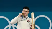 Rizki Juniansyah dari Indonesia meraih medali emas dari cabor angkat besi di Olimpiade 2024. (Miguel MEDINA / AF)