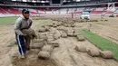 Pekerja memindahkan rumput yang ada di Stadion Utama Gelora Bung Karno (SUGBK), Jakarta, Jumat (18/5). Pemindahan rumput dilakukan agar kondisi rumput tak rusak saat persiapan pembukaan Asian Games 2018 mendatang. (Liputan6.com/Johan Tallo)