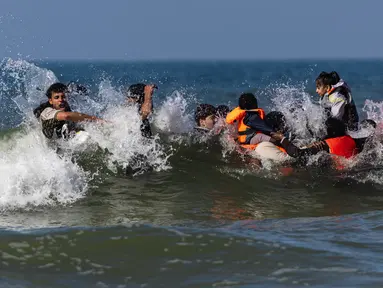 Migran berusaha menaiki perahu milik penyelundup dari pantai Equihen-Plage, Prancis utara, Rabu (23/9/2026), untuk menyeberangi Selat Inggris menuju Inggris. (Sameer Al-DOUMY/AFP)