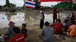 Penduduk setempat menunggu dimulainya pada festival lomba balap kerbau di Chonburi, Minggu (16/7). Festival tahunan di Thailand ini merupakan tradisi untuk menyambut datangnya musim panen padi. (LILLIAN SUWANRUMPHA / AFP)