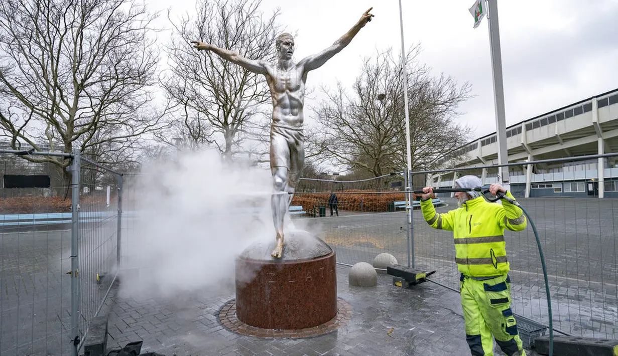 Petugas memebersihkan patung Zlatan Ibrahimovic yang rusak di depan Stadion Malmo FF, Swedia, Minggu (22/12). Perusakan patung tersebut dilakukan fans Malmo karena kecewa sang idola berinvestasi di klub rival, Hammarby. (AP/Johan Nilsson)