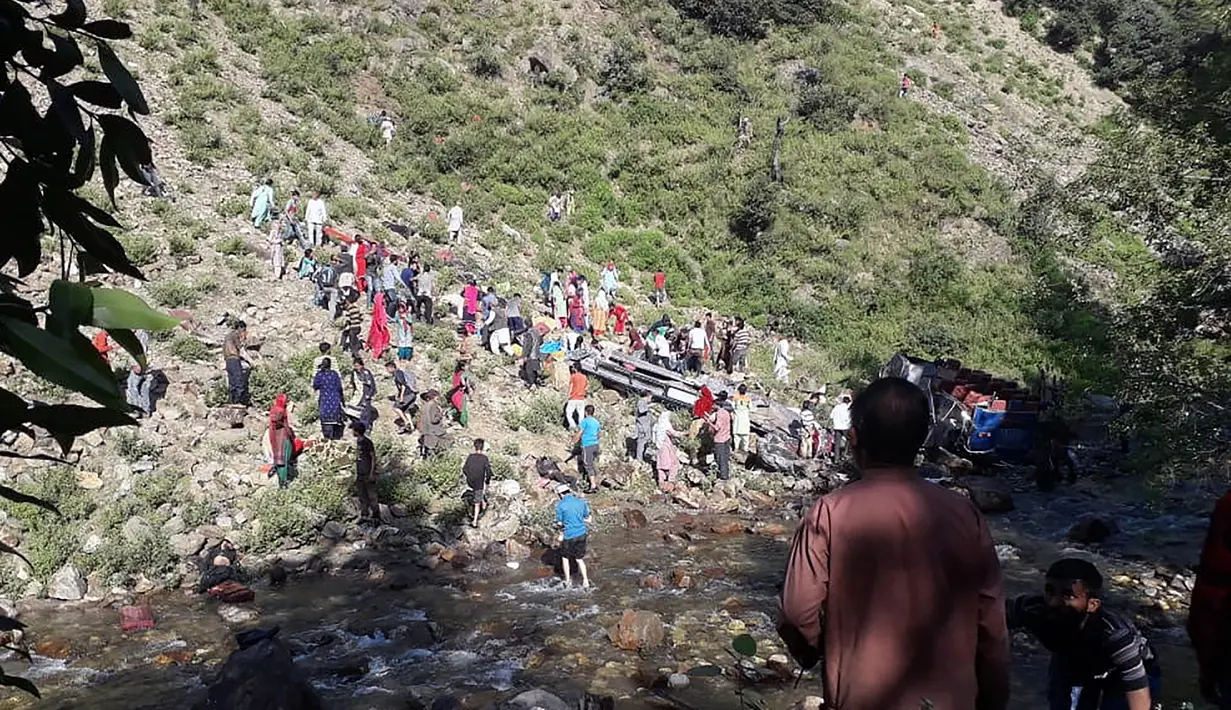 Tim penyelamat dibantu warga mengevakuasi korban kecelakaan bus di di wilayah Kishtwar di negara bagian Jammu dan Kashmir (1/7/2019). Sekitar 35 orang tewas dan 22 orang terluka akibat bus sarat penumpang tersebut terjun ke jurang. (AFP Photo/STR)