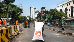Mereka tampak menggunakan alat seadanya untuk membersihkan abu sisa pembakaran yang dilakukan oleh massa pada saat demo di kawasan tersebut. (merdeka.com/Arie Basuki)